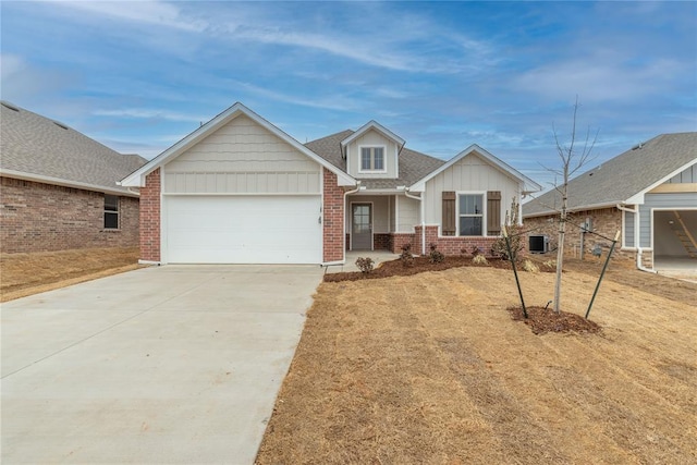 view of front of home featuring a garage, concrete driveway, cooling unit, board and batten siding, and brick siding