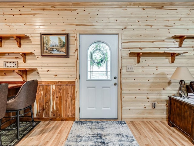 entryway featuring wood walls and light wood-type flooring