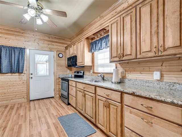 kitchen featuring stainless steel electric stove, wood walls, sink, and light wood-type flooring