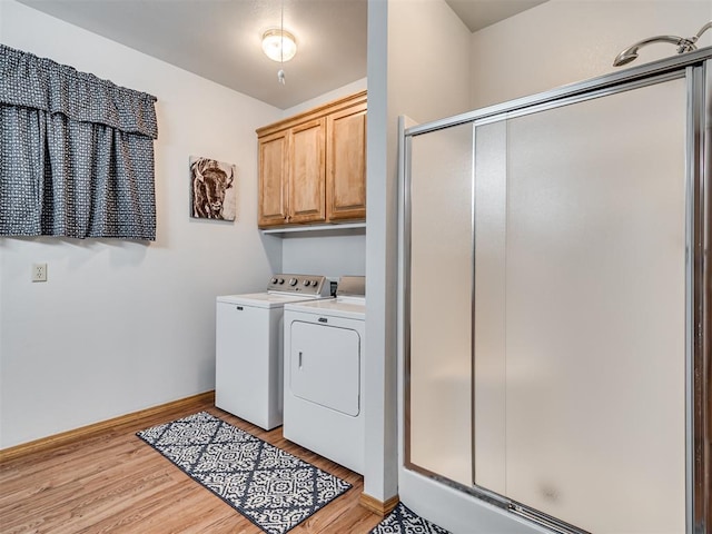 laundry area featuring cabinets, independent washer and dryer, and light hardwood / wood-style flooring