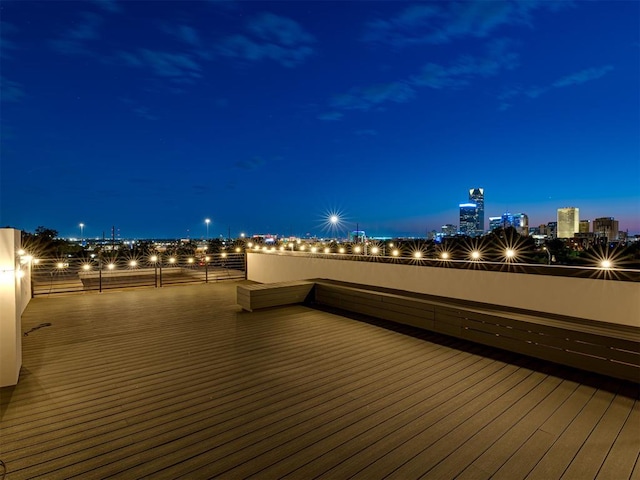 deck at twilight featuring a water view