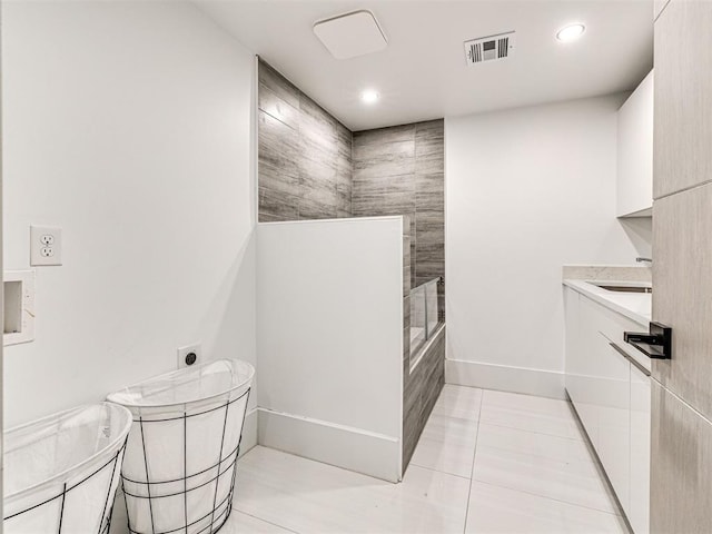 bathroom featuring tile patterned floors, vanity, and tiled shower / bath