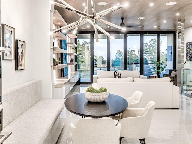 interior space with ceiling fan with notable chandelier and a wall of windows