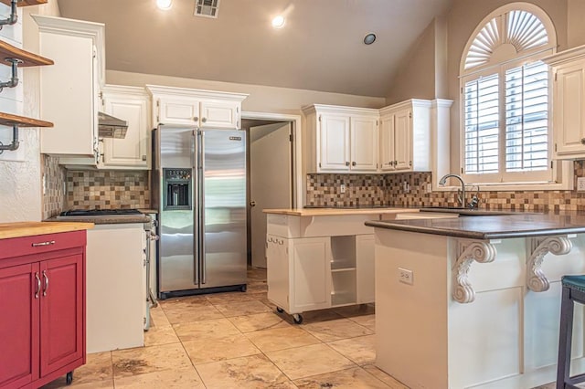 kitchen with a breakfast bar area, white cabinets, stainless steel appliances, and a center island