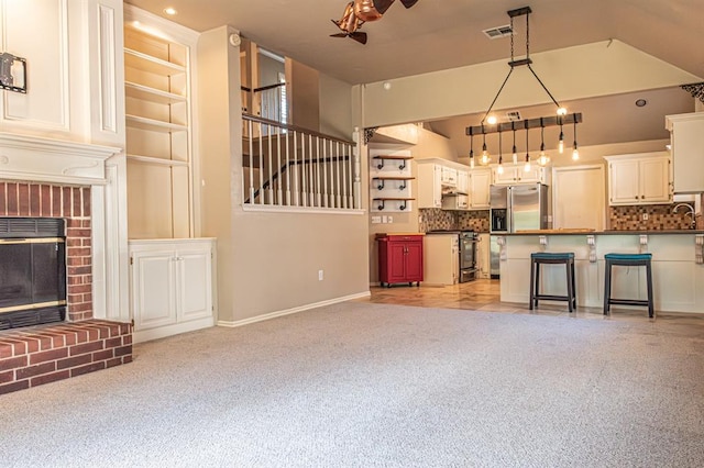 unfurnished living room featuring a brick fireplace, heating unit, light colored carpet, and sink