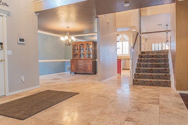 entrance foyer featuring crown molding and an inviting chandelier