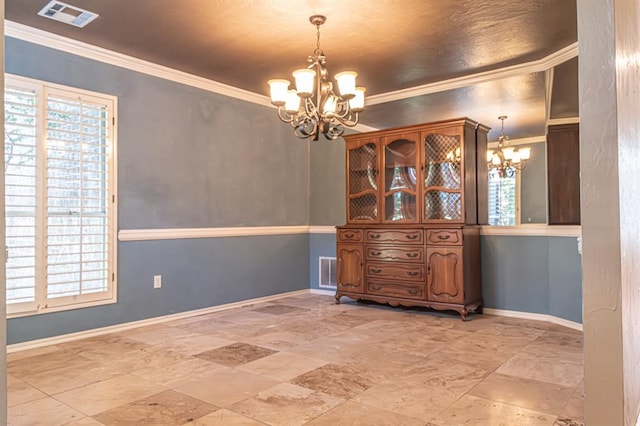 unfurnished dining area featuring ornamental molding, a notable chandelier, and a healthy amount of sunlight