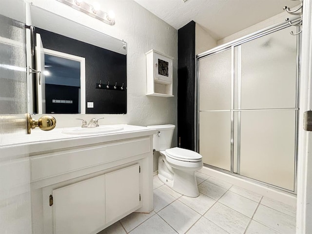 bathroom featuring toilet, tile patterned flooring, an enclosed shower, and vanity