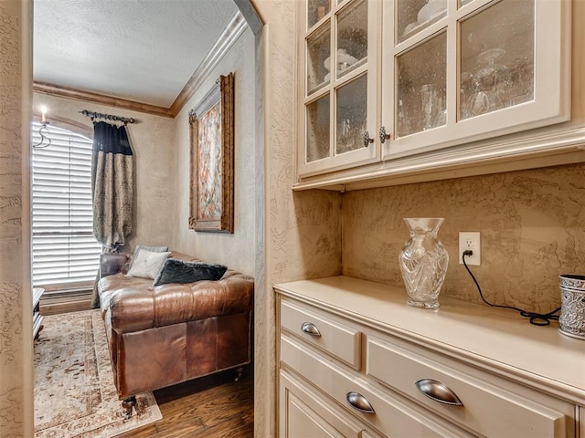 sitting room with a textured ceiling, dark hardwood / wood-style floors, and crown molding