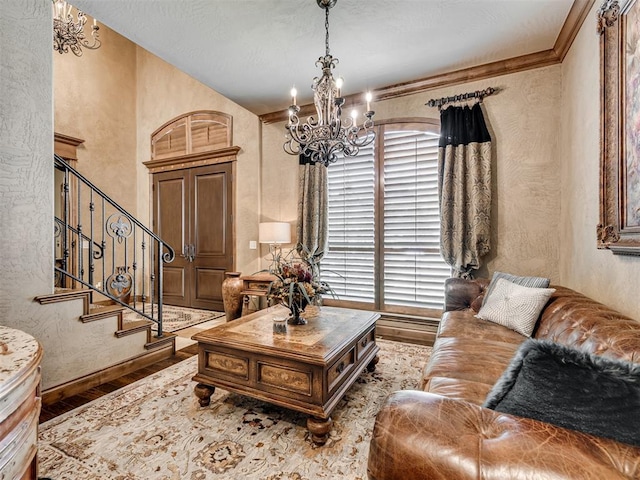 living room with hardwood / wood-style floors, plenty of natural light, ornamental molding, and an inviting chandelier