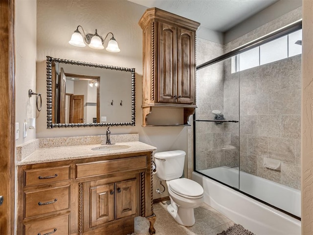 full bathroom featuring tile patterned floors, toilet, combined bath / shower with glass door, and vanity