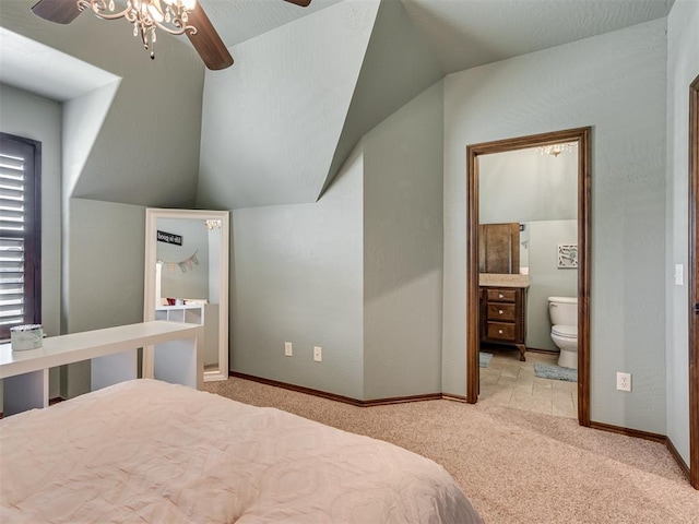 carpeted bedroom with connected bathroom, ceiling fan, and vaulted ceiling