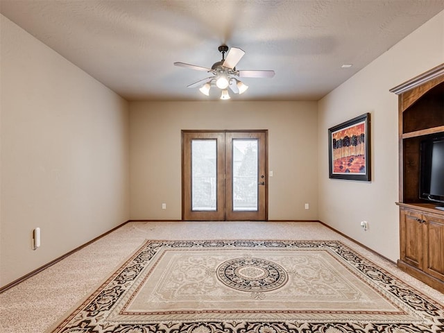 unfurnished living room featuring light carpet, french doors, a textured ceiling, and ceiling fan