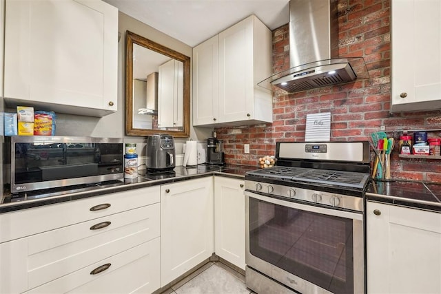 kitchen featuring white cabinets, wall chimney exhaust hood, decorative backsplash, and appliances with stainless steel finishes