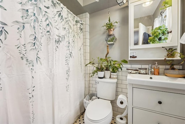 bathroom with vanity, tile walls, and toilet