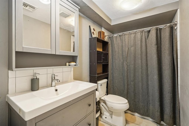 bathroom with walk in shower, tasteful backsplash, tile patterned floors, toilet, and vanity