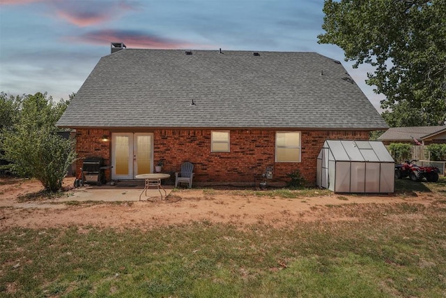 back house at dusk featuring a yard