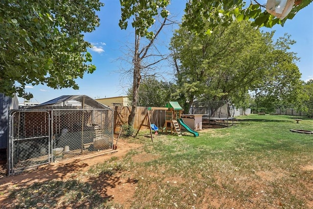 view of yard featuring a playground, an outbuilding, and a trampoline