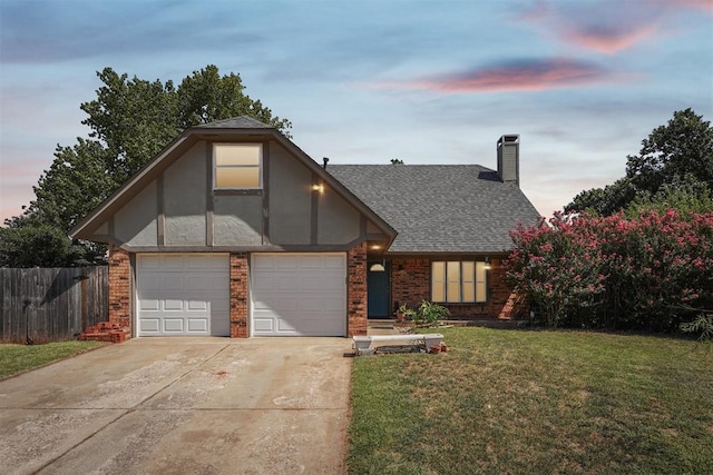 tudor home featuring a lawn and a garage