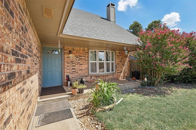 entrance to property featuring a lawn