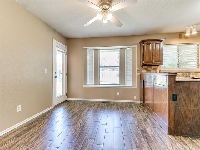 kitchen featuring ceiling fan, backsplash, and dark hardwood / wood-style flooring