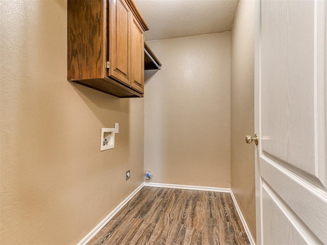 laundry room with cabinets, a textured ceiling, dark hardwood / wood-style flooring, hookup for a washing machine, and hookup for an electric dryer