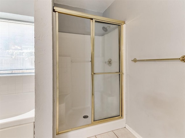 bathroom featuring tile patterned floors and shower with separate bathtub