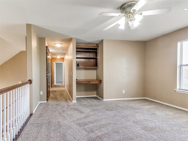 interior space featuring built in desk and ceiling fan