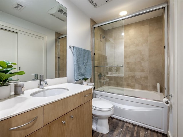 full bathroom with wood-type flooring, vanity, toilet, and enclosed tub / shower combo