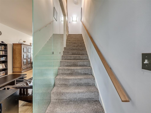 stairs with hardwood / wood-style flooring and vaulted ceiling