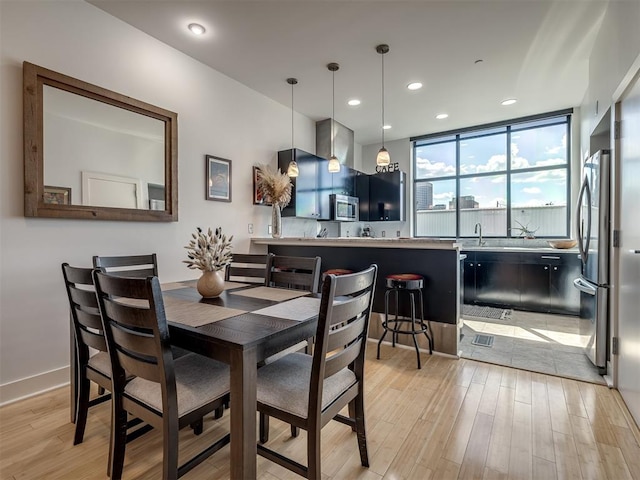 dining space featuring light hardwood / wood-style flooring and sink