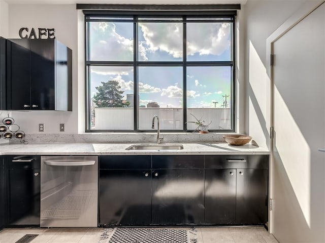 kitchen with light stone counters, sink, light tile patterned flooring, and stainless steel dishwasher