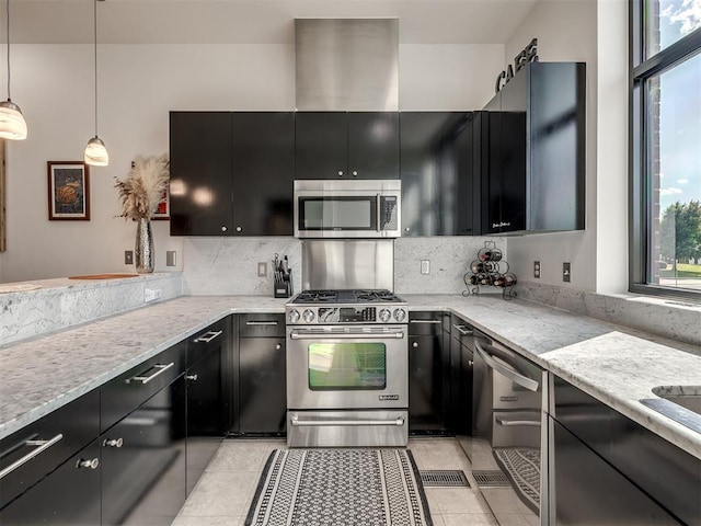 kitchen featuring decorative backsplash, light stone countertops, decorative light fixtures, and appliances with stainless steel finishes