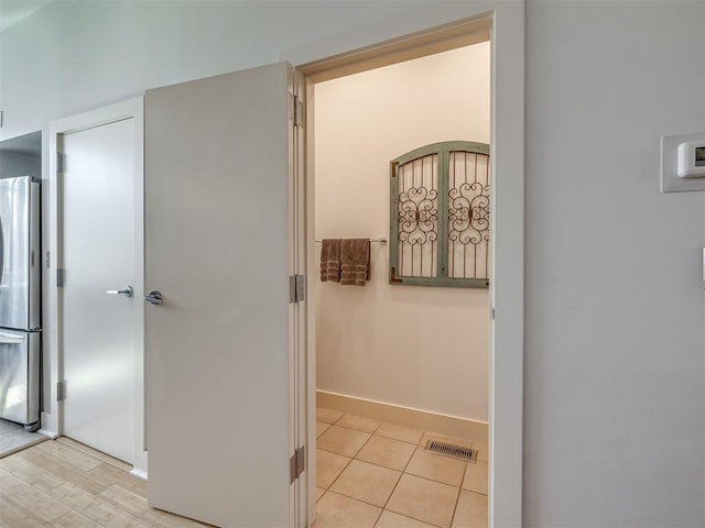 corridor featuring light tile patterned floors