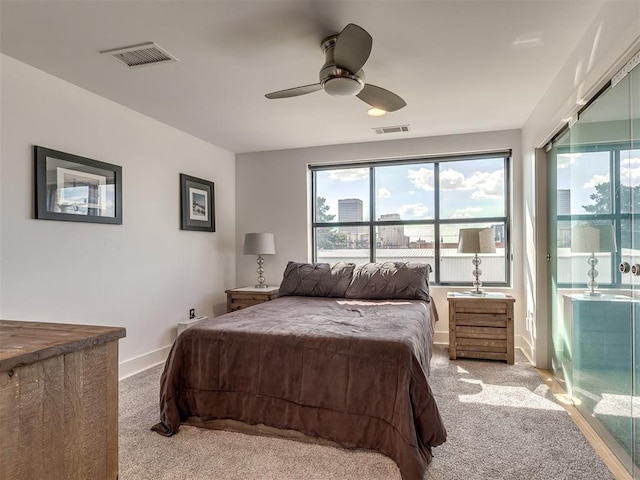 bedroom featuring ceiling fan, light colored carpet, and multiple windows