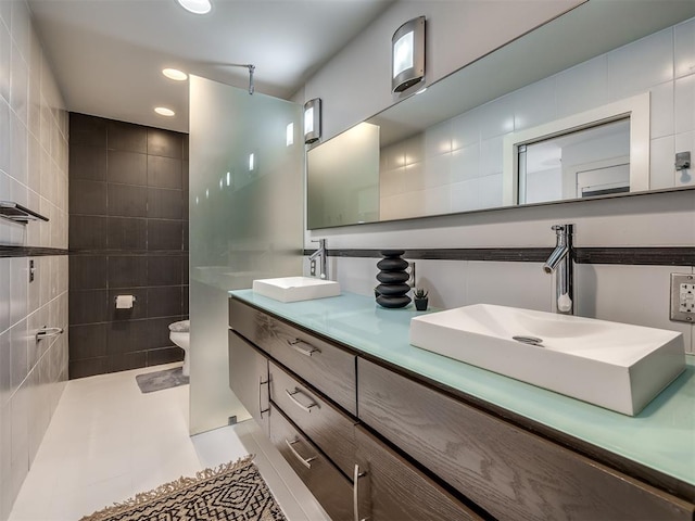 bathroom with toilet, vanity, and tile patterned floors