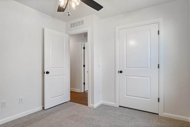 unfurnished bedroom with ceiling fan and light colored carpet