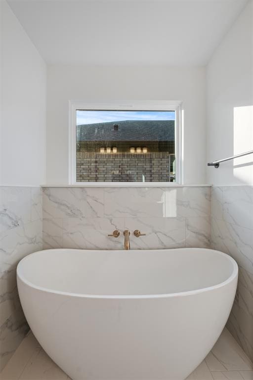 bathroom featuring a bathtub and tile walls