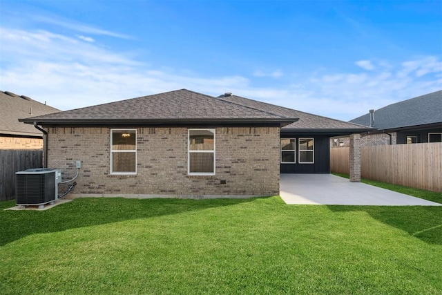 rear view of house featuring a lawn, central air condition unit, and a patio