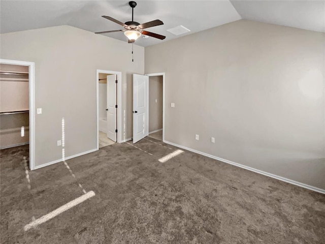 unfurnished bedroom featuring ensuite bath, a spacious closet, ceiling fan, and vaulted ceiling