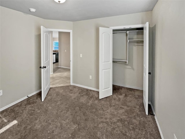 unfurnished bedroom featuring dark colored carpet and a closet