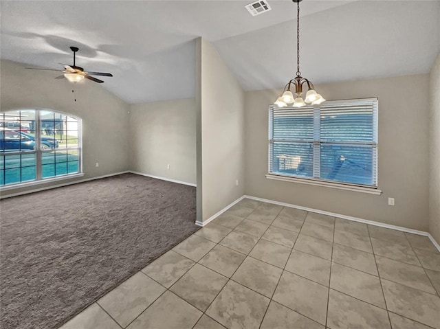 tiled spare room featuring ceiling fan with notable chandelier and vaulted ceiling