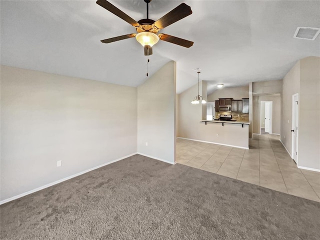 unfurnished living room featuring light carpet, ceiling fan with notable chandelier, and vaulted ceiling