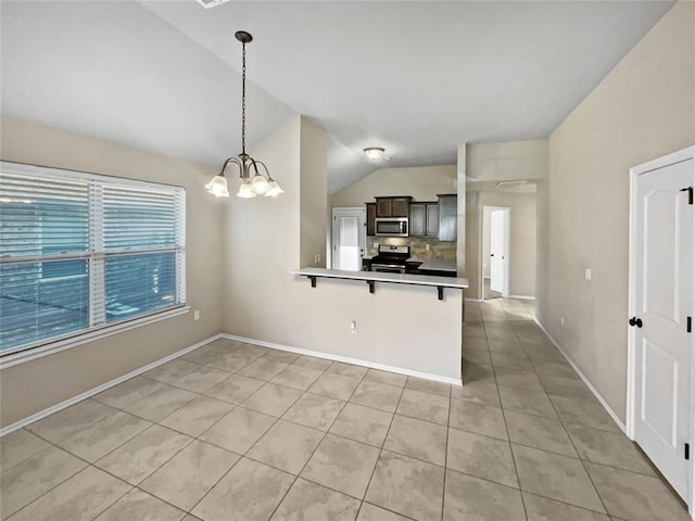 kitchen with lofted ceiling, hanging light fixtures, appliances with stainless steel finishes, kitchen peninsula, and a breakfast bar area