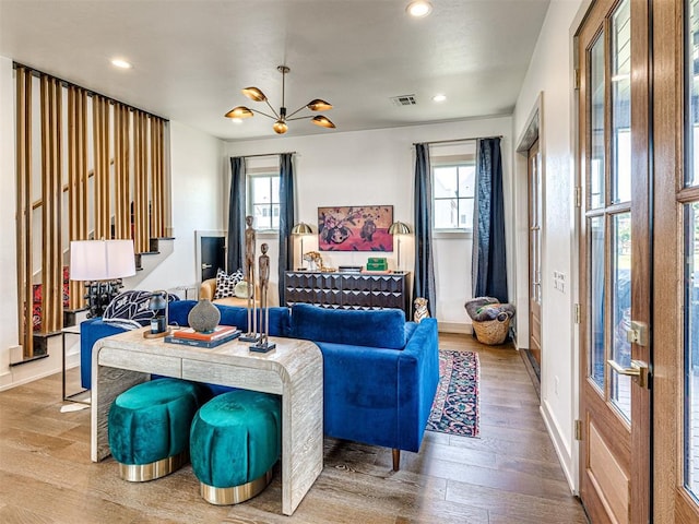 living room with hardwood / wood-style floors and a notable chandelier