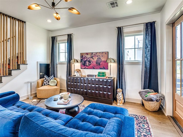 living room with hardwood / wood-style floors and a notable chandelier