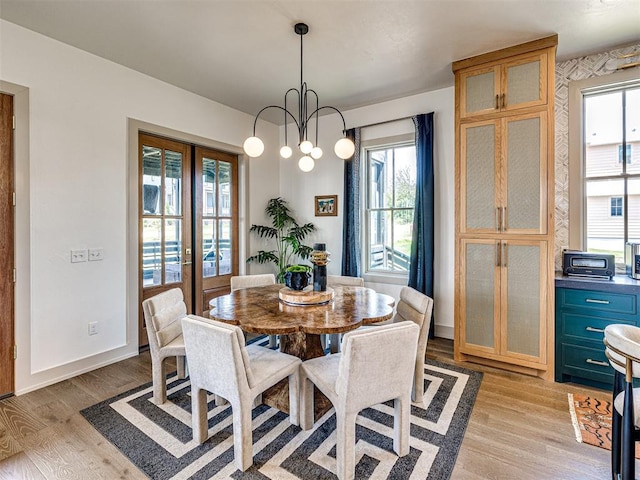 dining room with a notable chandelier and light wood-type flooring