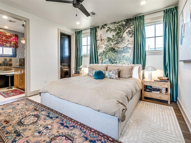 bedroom featuring wood-type flooring, connected bathroom, and ceiling fan