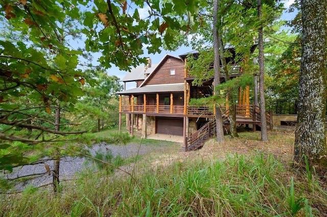 rear view of property featuring a garage and a deck