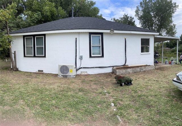 view of side of home featuring a lawn and ac unit